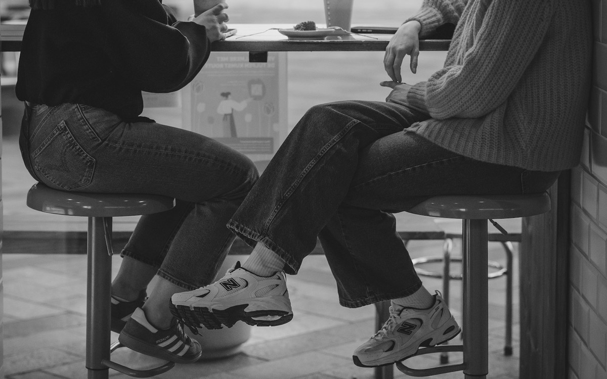 Two women talking together at a cafe counter